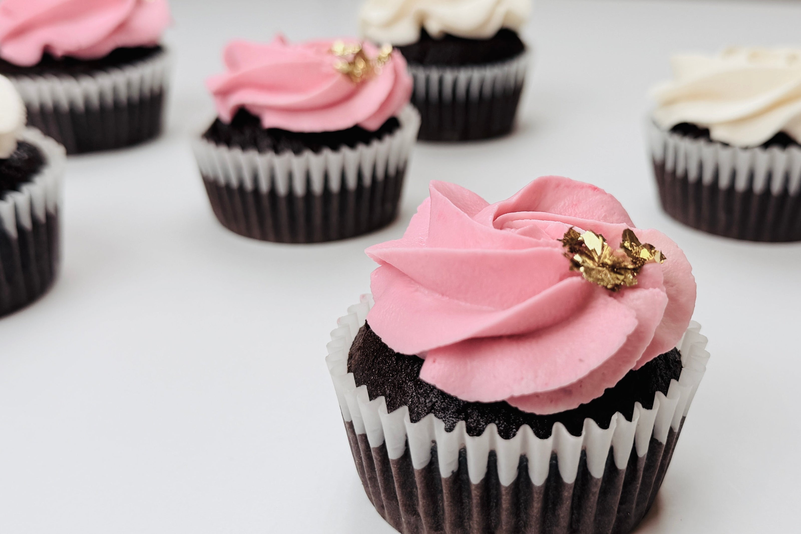 Cupcakes mit rosanem und weißem Frosting, dekoriert mit Blattgold von Goldzucker in Ostfildern bei Stuttgart